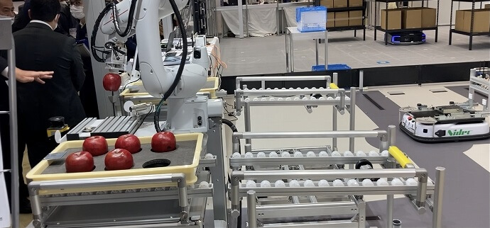 リンゴを優しくつかむアーム型ロボット
